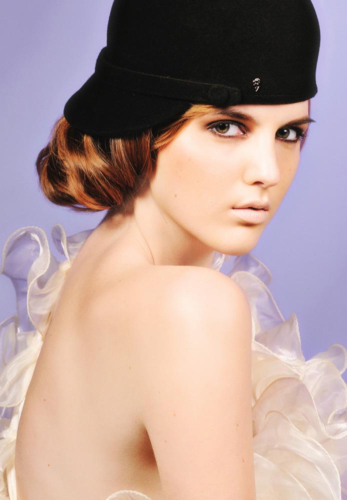 Colour Hats & Beauty in The Studio, Blue Background black cap with Adele Thiel Model, full high key make-up, white lips. Photography by Kent Johnson, Sydney, Australia.