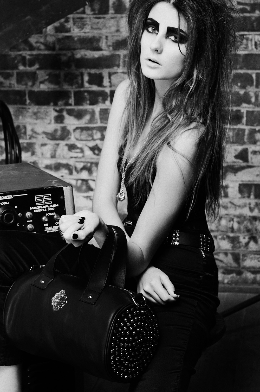 Intense black and white photography model clutching leather tote, for the biker fashion inspired fashion handbag campaign, photographed by Kent Johnson, Sydney Australia.