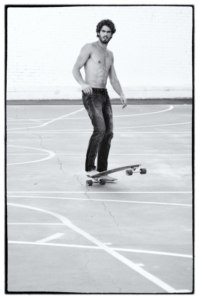Weathered black denim jeans, model skateboarding on a basketball court, black and white photograph by Kent Johnson, Sydney Australia.