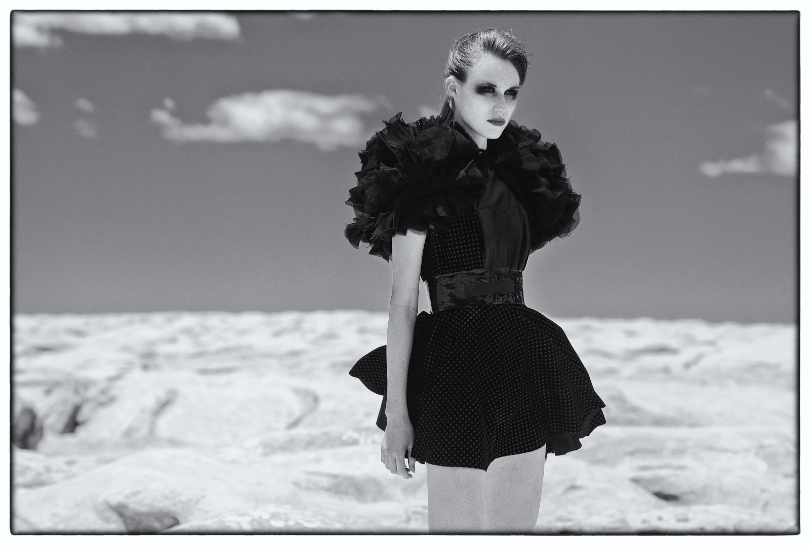 Fashion Magazine Photography Sydney, The Girls Who Fell To Earth, Spotted black dress with ruffled sleves in a hostile moonscape landscape. Photo by Kent Johnson.