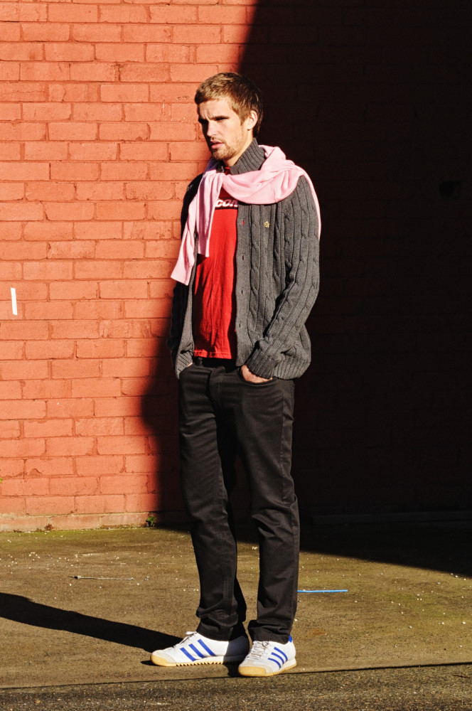 Rapture In Sydenham - Man wearing MERC Pyland Pink Knit Jumper & Sneath Charcoal Knit button front Cardigan. Thrift shop ‘new’ Red SAUCONY Tee. Editorial Fashion Photography by Kent Johnson.