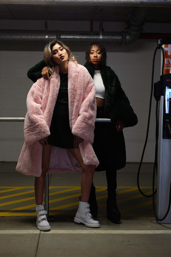 Two models in big heavy faux fleece coats in a car park for Somewhere Label. Fashion photography by Kent Johnson