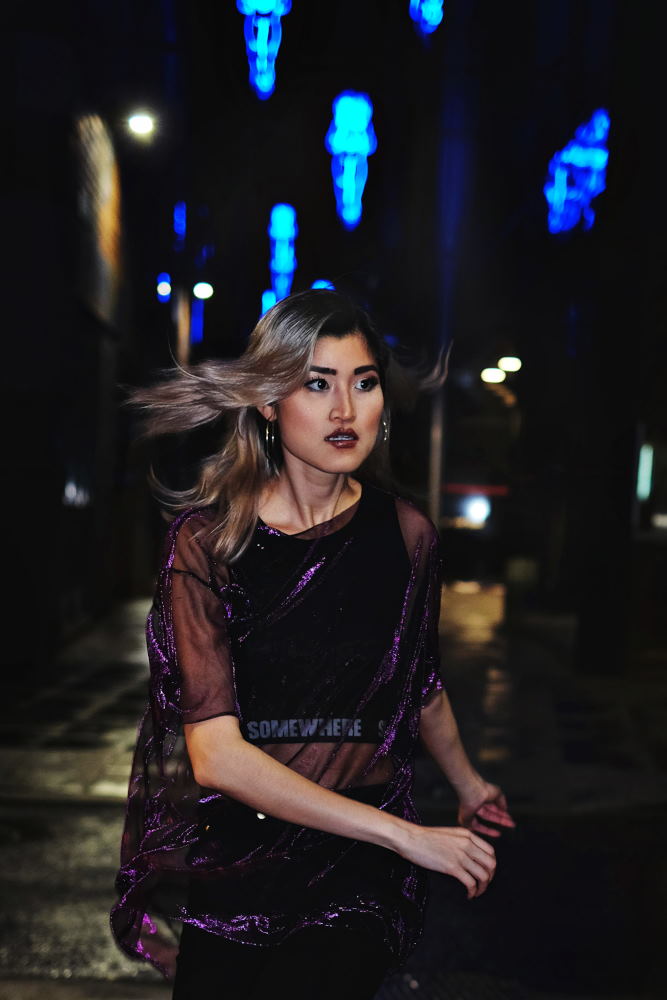 Night location and neon lights, model running in purple top photoshoot in Sydney for Somewhere Label. Photography by Kent Johnson.