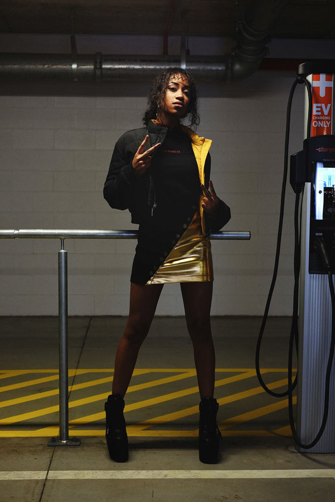 Vee for get lost! Model in puff jacket and meatalic skirt, elevator boots. Parking garage photoshoot in Sydney for Somewhere Label. Fashion photography by Kent Johnson