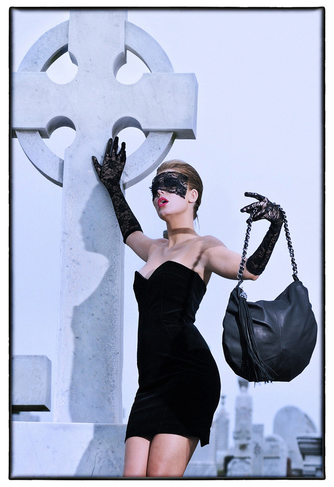 Gothic Fashion Model in old cemetery Skull and Bones Handbag Campaign.