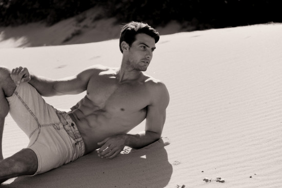 Mitch reclining on the sand dune. Tanning product campaign shoot.