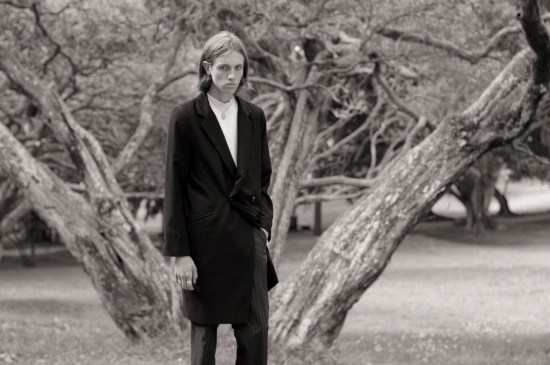 Black and white photoshoot menswear in the park, dark coat, white skivvy. Male modelling, Sydney, Australia.