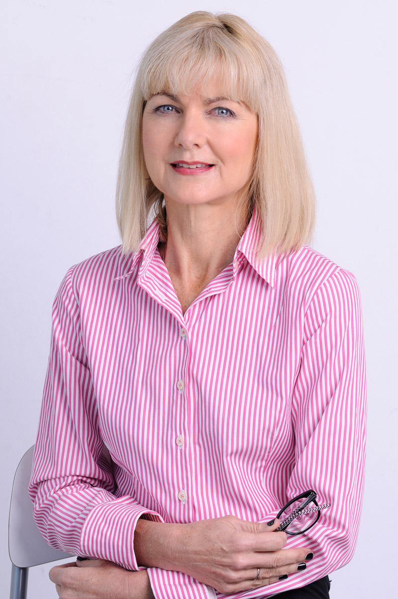 Portrait of a woman in pink pin stripe business shirt. Corporate business portraits in Sydney by portrait photographer by Kent Johnson.