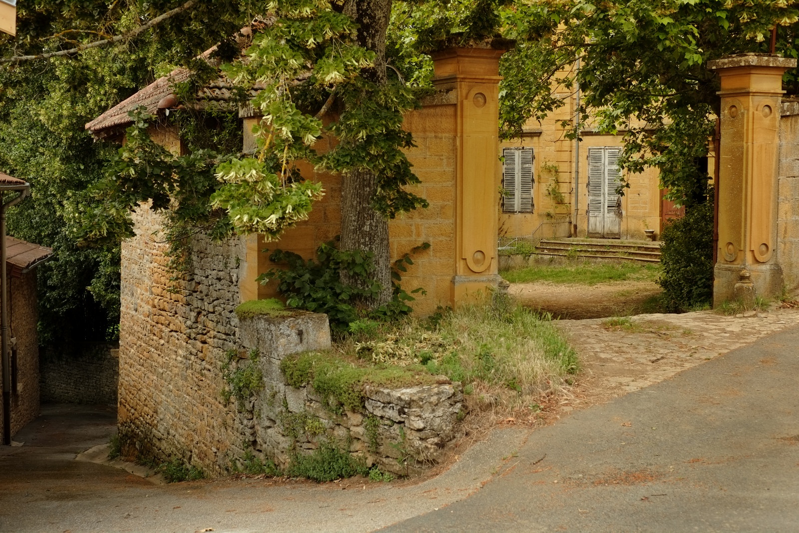A golden stone gateway and Maison, Bagnols, France. Travel and architectural photography by Kent Johnson