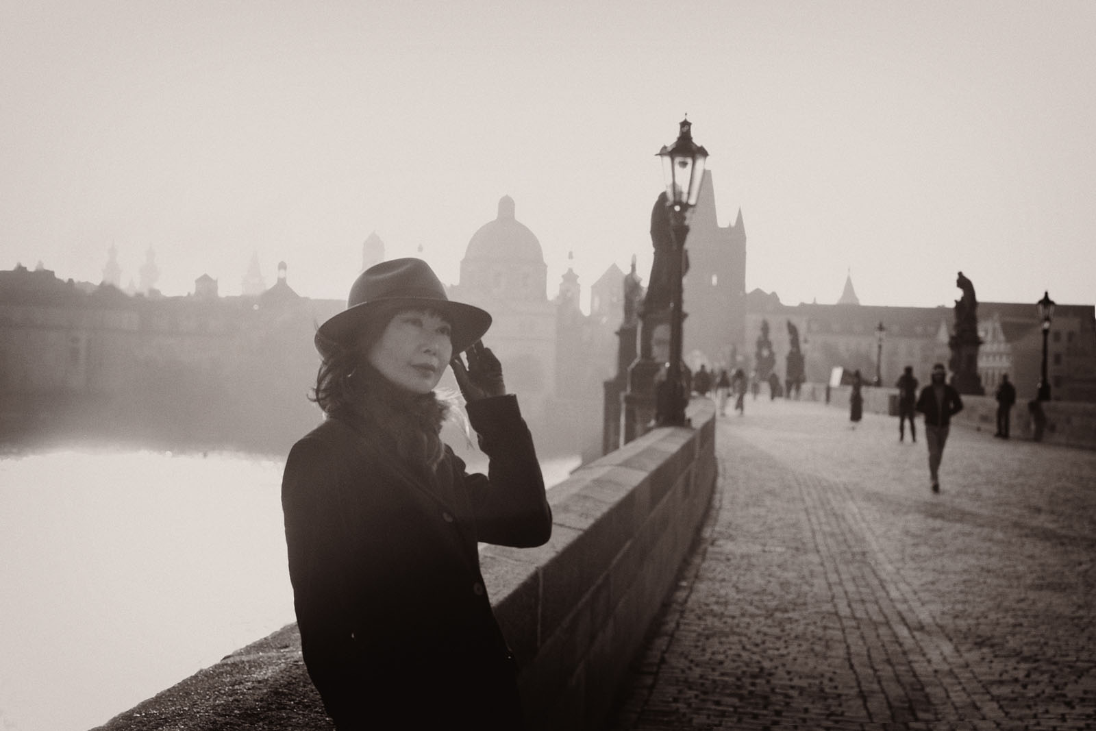 A dawn portrait on the Charles bridge, Prague as the sun rises in the backround. Travel photography by Kent Johnson.