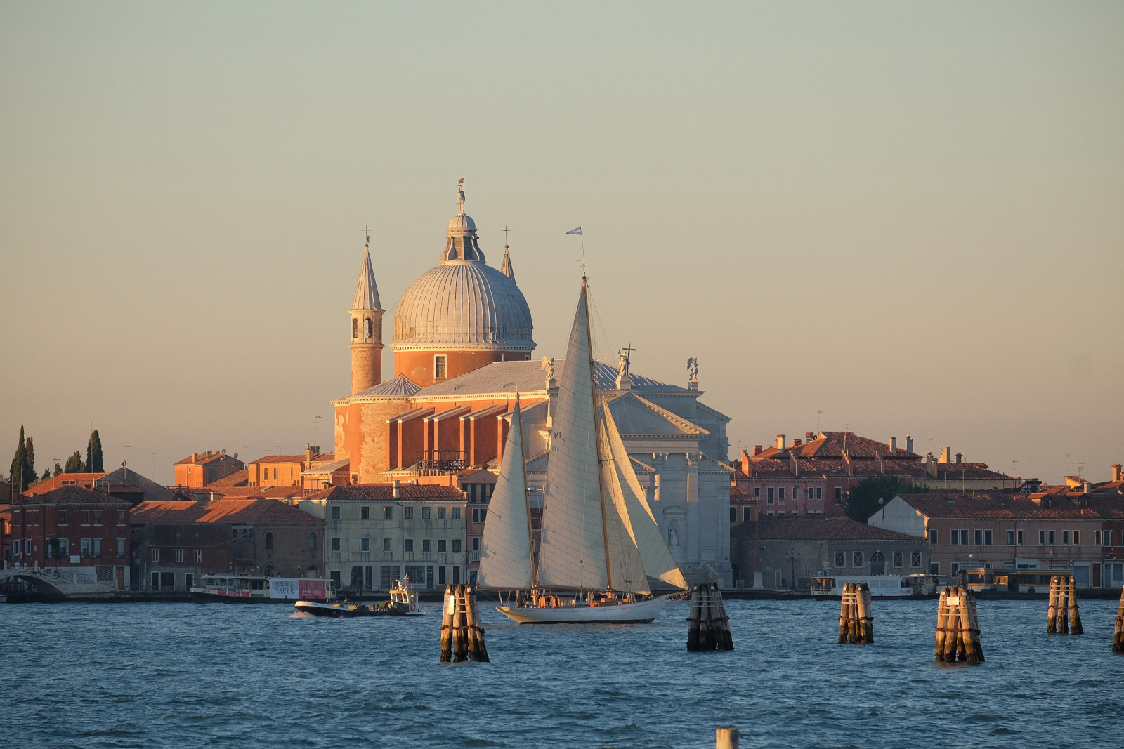 Venice, Italy, a classic sailing yacht cruises past San Giorgio Maggiore at dawn. Travel photography by Kent Johnson.