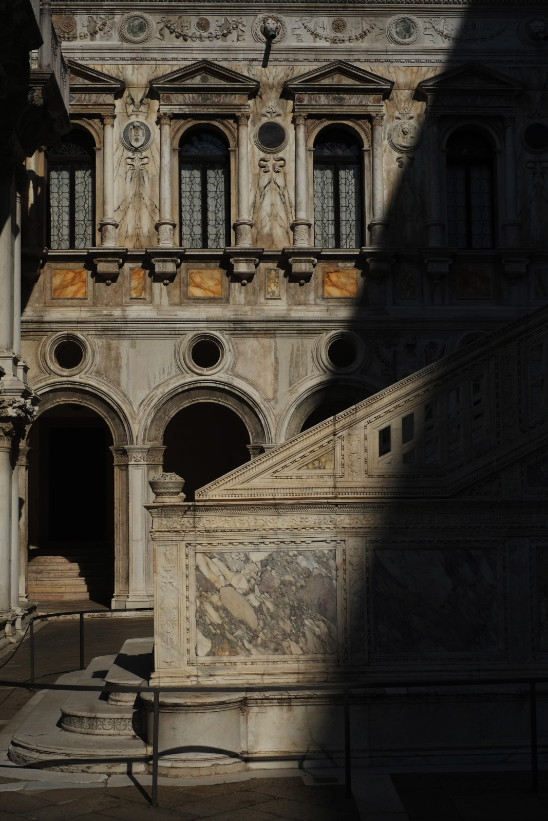 Marble arches, columns walls and stairs in strong shadows and light, courtyard of the Doge's Palace, Venice,Italy.