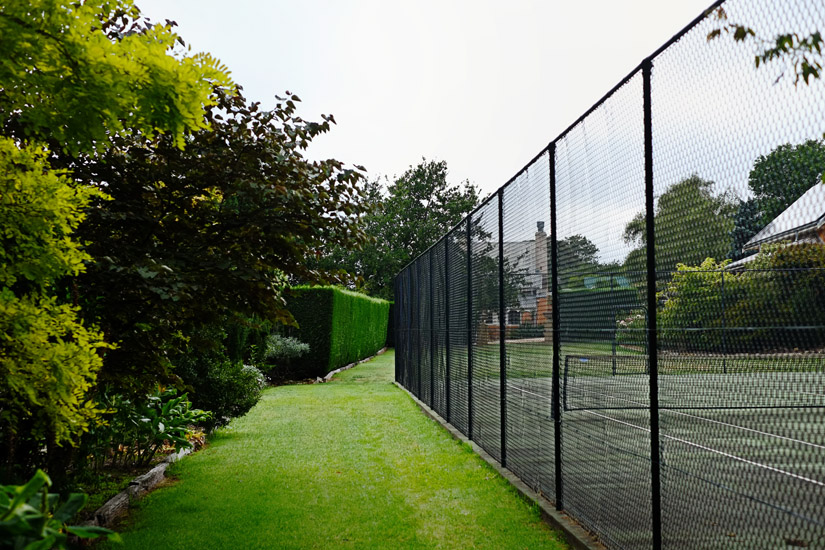 View of the tennis court with gardens and hedges; Fitzroy Inn, Southern Highlands, NSW. Garden and Travel photography by Kent Johnson.