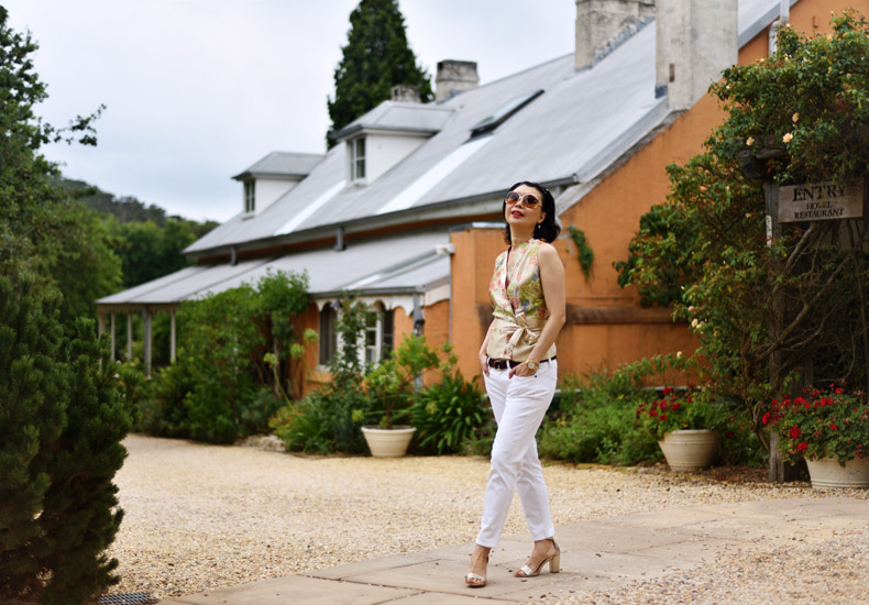 A guest stroles along a path with the historical Fitzroy Inn and garden shrubs in the backround. lifestyle and travel photography by Kent Johnson.