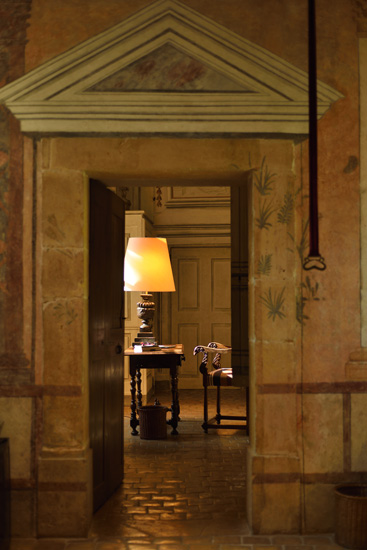 Doorway to the bedroom suit, detail of writing table chair and lamp, painted wall murals. Hotel and resort photography by Kent Johnson.