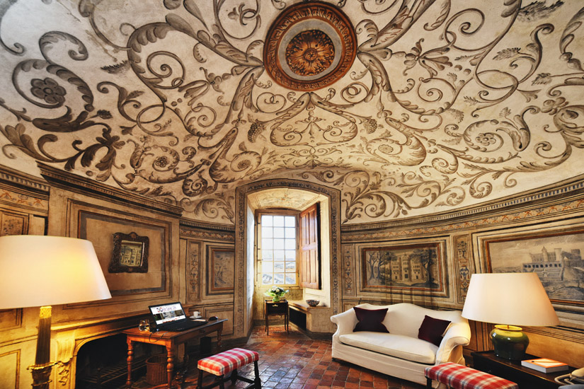 Circular lounge room with beautiful painted ceiling and wall murals in the tower of a restored French château, now a 5 star hotel. Travel photography by Kent Johnson.