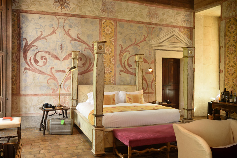 Details of the stenciled walls and four poster bed in the bright and airy castle hotel suite. Hotel interior photography by Kent Johnson.