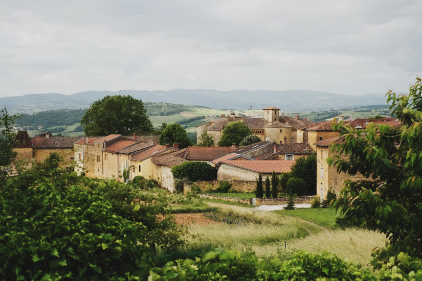 The rolling hills of the Beaujolais wine region with a view of Château de Bagnols & the village of Bagnols. Travel photography by Kent Johnson.
