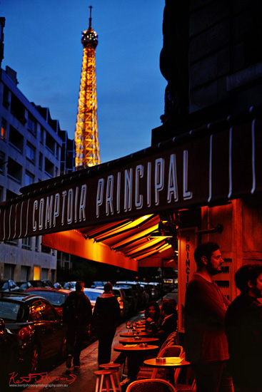 A street view of the Eiffel Tower and classic french bistro at night. Lifestyle photography by Kent Johnson. A street view of the Eiffel Tower and classic french bistro at night. Lifestyle photography by Kent Johnson.