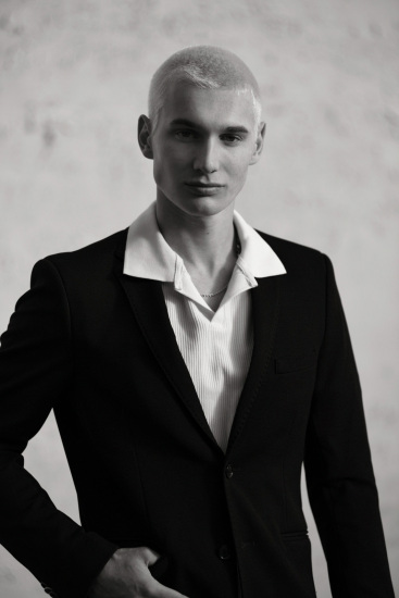 Menswear fashion shoot in black and white, male model in dark blazer, casual shirt.