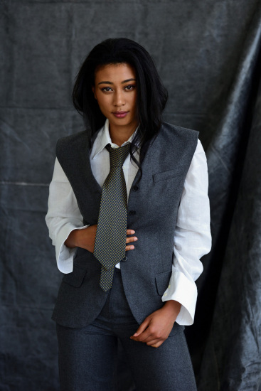 Female model wearing grey flannel suit, white shirt and silk necktie – studio portfolio shoot.