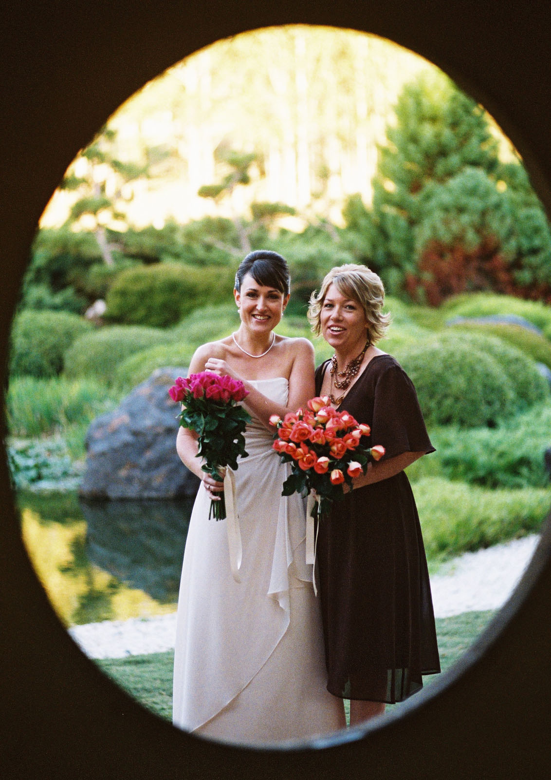 Bride and bridesmaid at a garden wedding. Weddings, are perhaps the biggest occassion of all. Photographed by Kent Johnson.