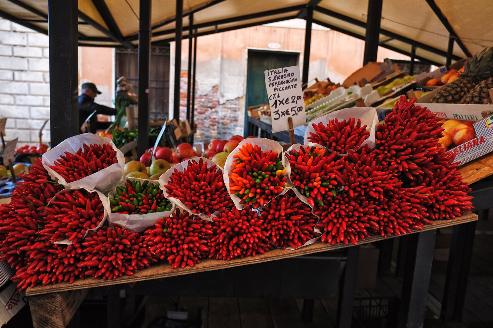 Bundles of red chili peppers on a market stall table at the Rialto Markets. Travel and lifestyle photography by Kent Johnson.
